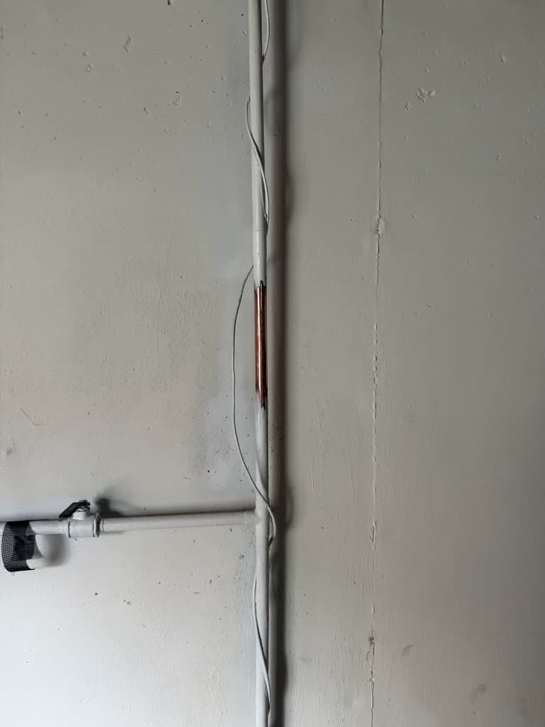 Copper pipe with repair splice in basement wall before PRV installation — Northern Colorado plumbing repair by Oopsie Daisy Plumbing