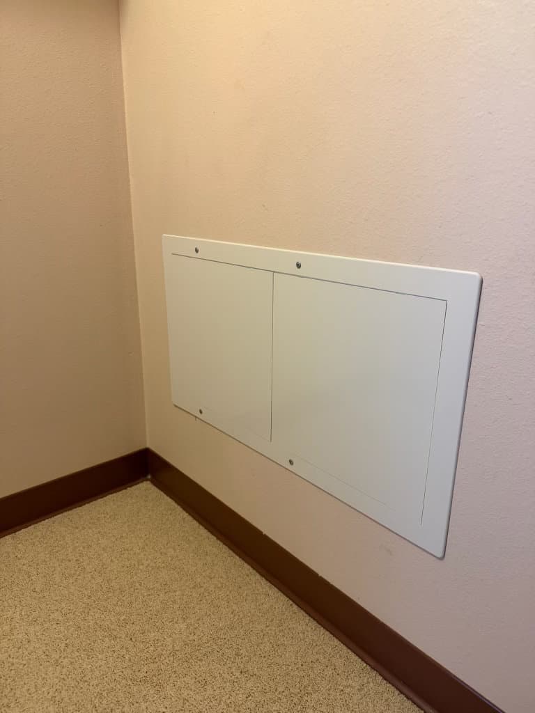 After: finished plumbing access panel flush in wall with carpet restored — Oopsie Daisy Plumbing Northern Colorado