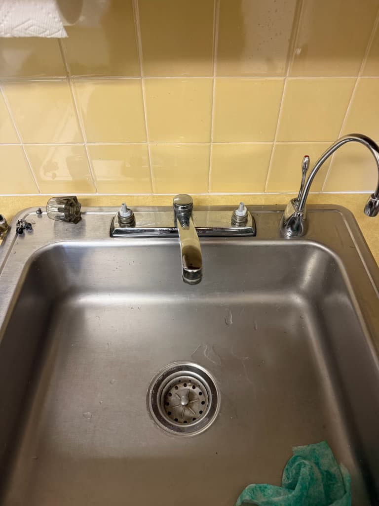 Before: old kitchen faucet with handles loosened for removal — Northern Colorado kitchen plumbing repair